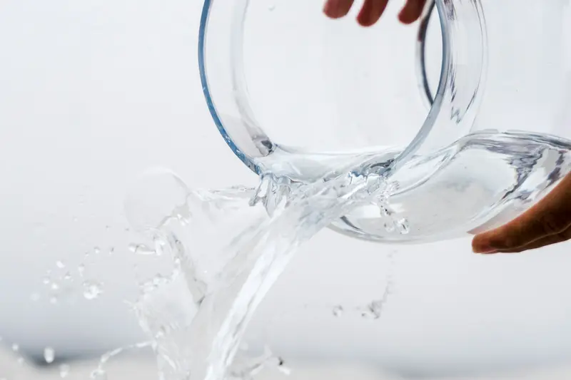 Water pouring from a clear glass jar